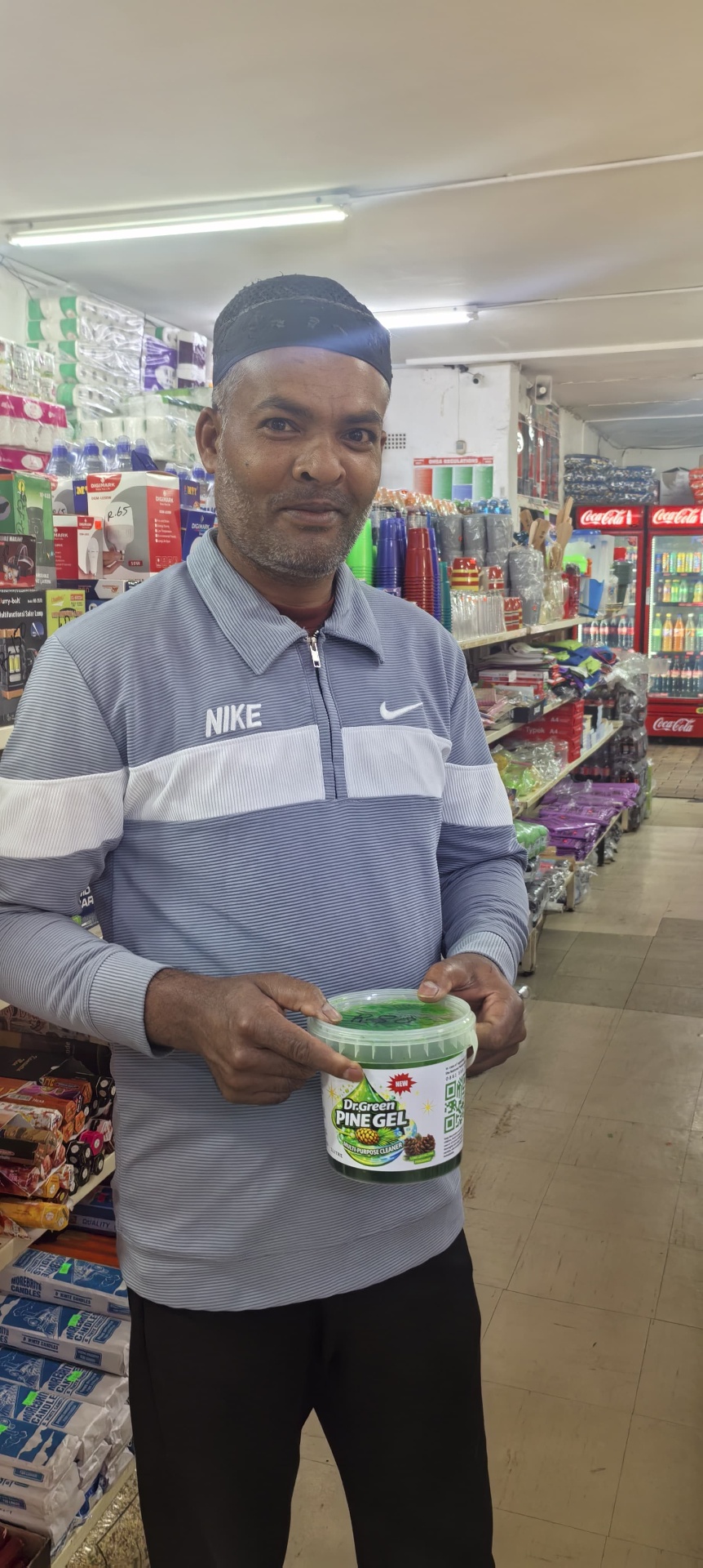 Happy customer holding a tub of Dr Green Pine Gel in store